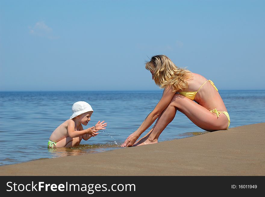 Mother with child plays on the beach