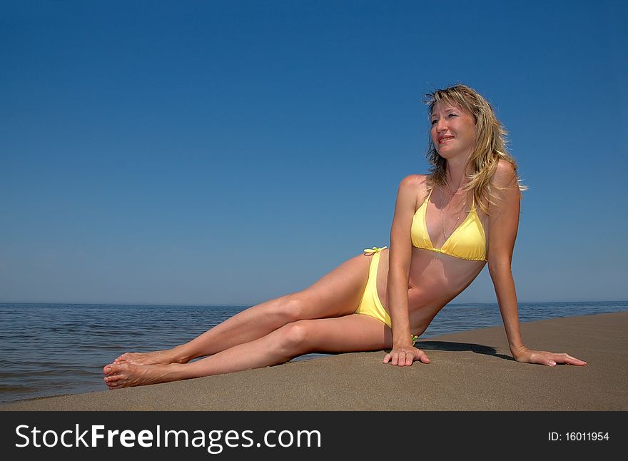 The beautiful woman sits on the beach. The beautiful woman sits on the beach