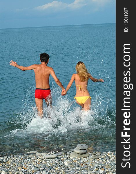 Young couple run in water