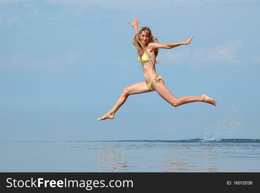 The woman in a bathing suit jumps on water. The woman in a bathing suit jumps on water