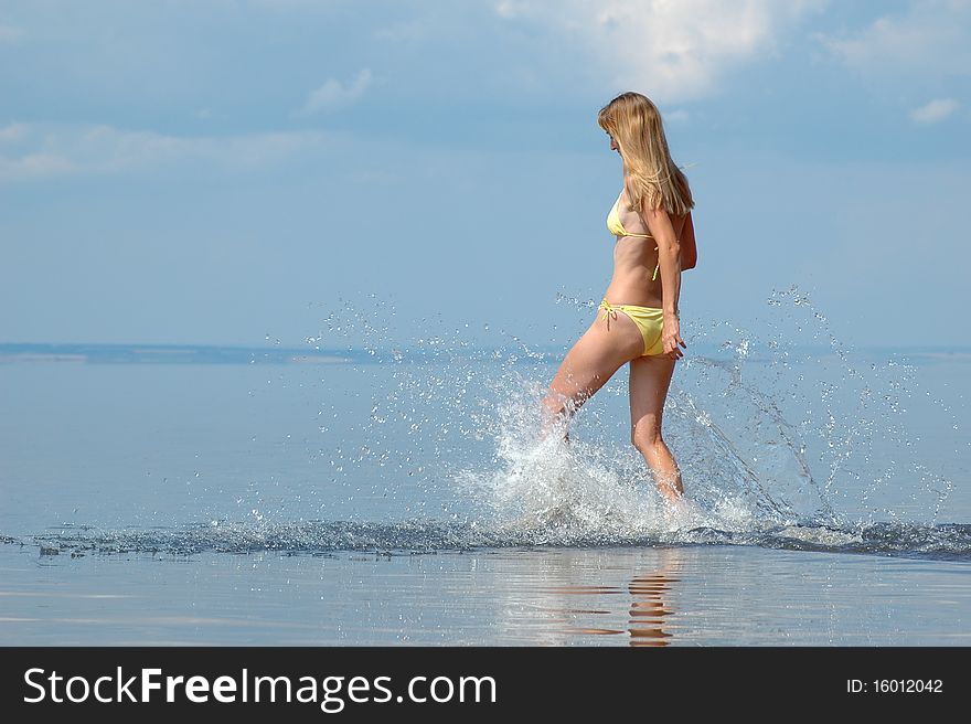 Young woman in bikini splash on water