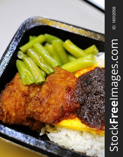 Malay rice set meal with fried fish cutlets. Concepts such as food and beverage, and travel and cuisine, and health and nutrition. Malay rice set meal with fried fish cutlets. Concepts such as food and beverage, and travel and cuisine, and health and nutrition.