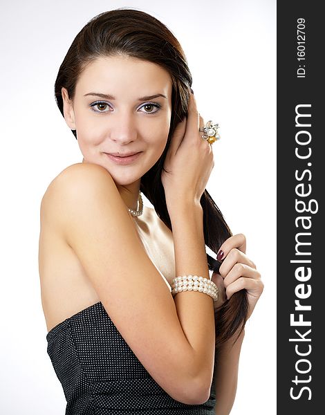 Fashion portrait of a woman in a casual dress holding her hair isolated on white