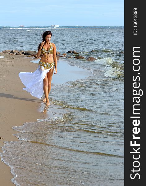 Beautiful young girl walking on beach