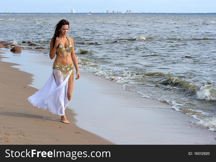 Beautiful young girl walking on the beach