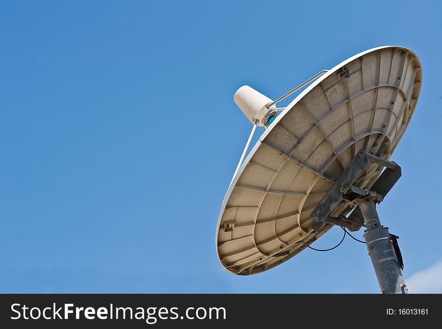 White satellite dish with clear blue sky. White satellite dish with clear blue sky