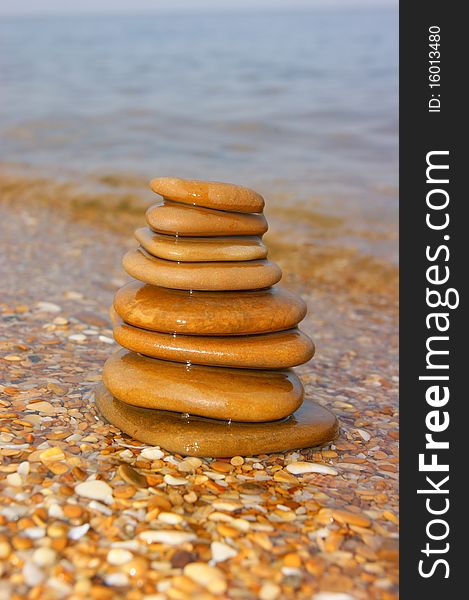 Stones on seacoast. A pyramid from stones. Flat sea stones. A pyramid on a beach.