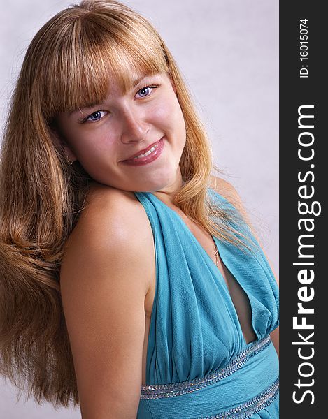 Girl in a blue long dress on a light grey background