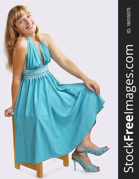 Girl in a blue long dress on a light grey background