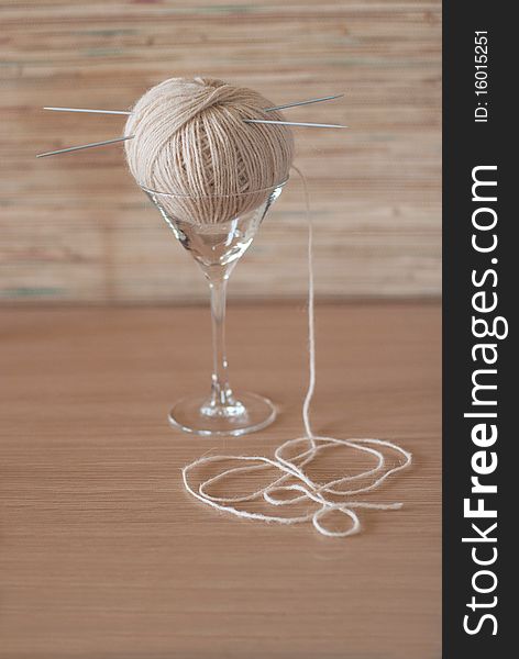 Ball of wool with needles in an elegant glass. Ball of wool with needles in an elegant glass