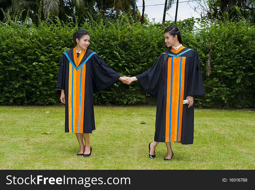 Two proud and happy asian students posing on their graduation day. Two proud and happy asian students posing on their graduation day