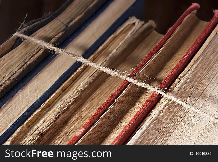 Archival books in a book-depository are tied up by a cord. Archival books in a book-depository are tied up by a cord.