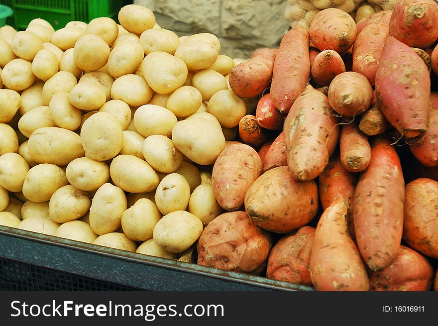 White and sweet potatoes on market stand