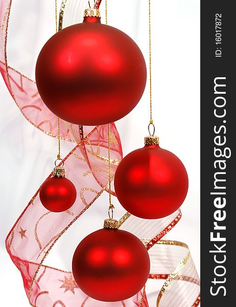Hanging red glass balls with the ribbon on the white background. Hanging red glass balls with the ribbon on the white background