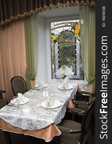 Restaurant interior: a dining table, chairs and a window with a kind on street