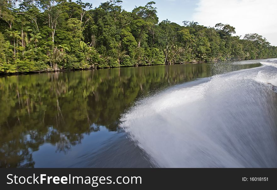 Water spray by fast moving boat on a tropical waterway