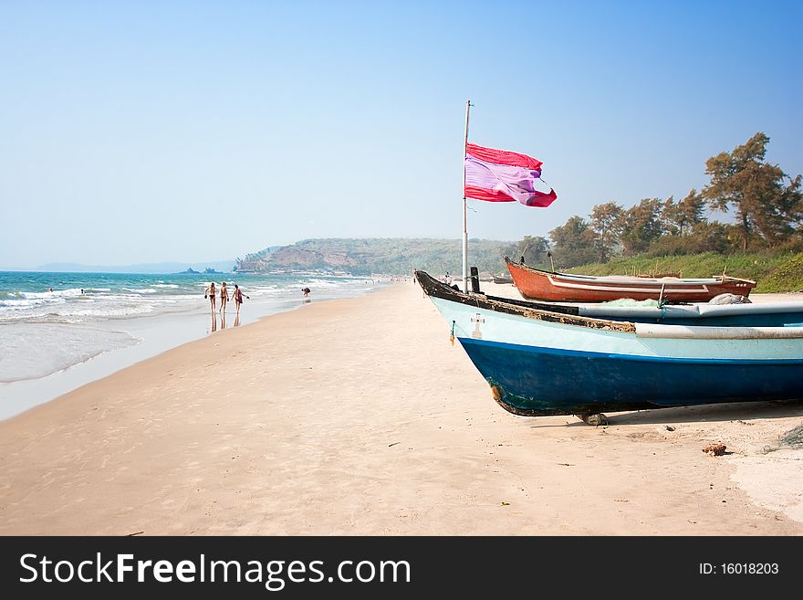 Wooden outrigger fishing boat with flag at Arambol (Harmal) beach, Goa India