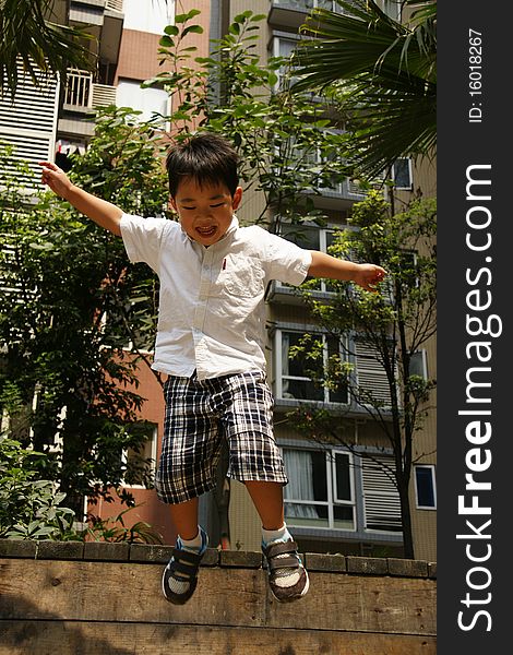 Picture of a little chinese boy jupming happily and having great fun. Picture of a little chinese boy jupming happily and having great fun