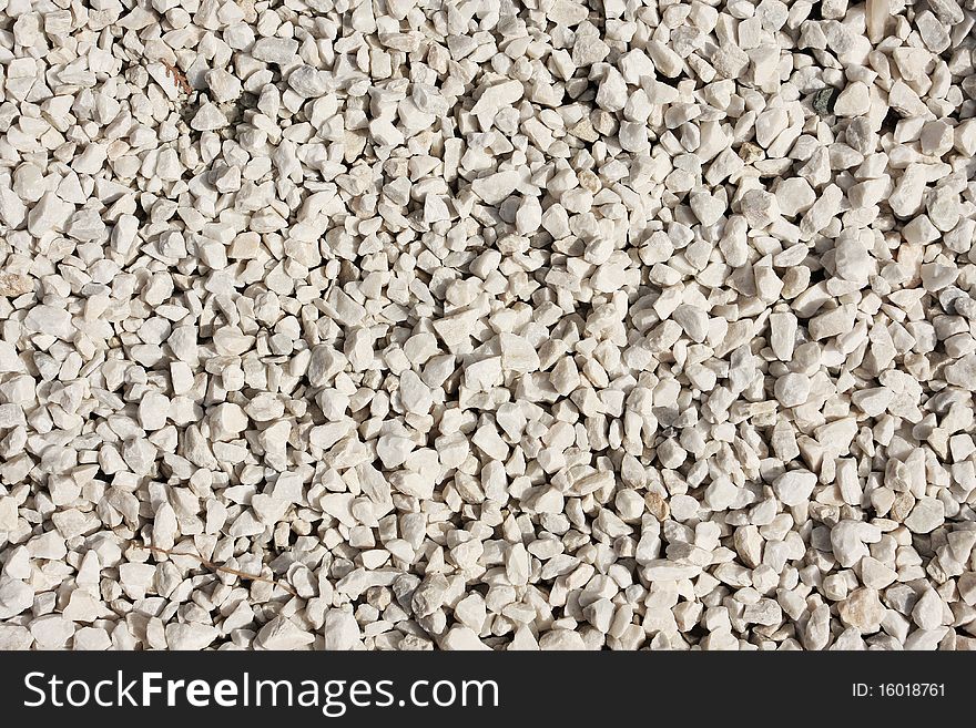White marble pebbles forming a compact background. White marble pebbles forming a compact background