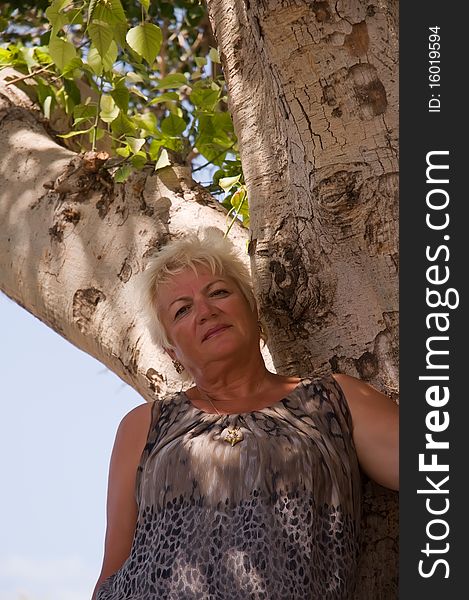 Casual portrait of happy mature woman against  the background of the tree. Casual portrait of happy mature woman against  the background of the tree.