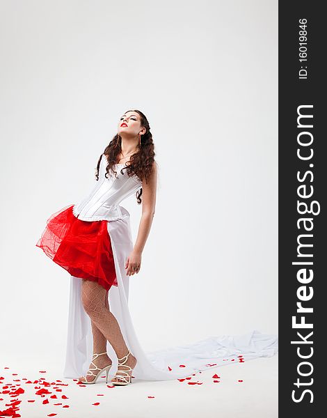 Young beautiful woman with petals of roses, on a white background