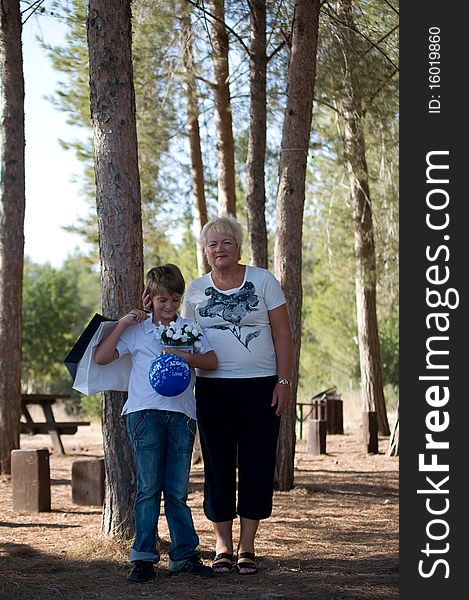 Boy with balloons and gifts worth with his grandmother on the background of nature. Boy with balloons and gifts worth with his grandmother on the background of nature.