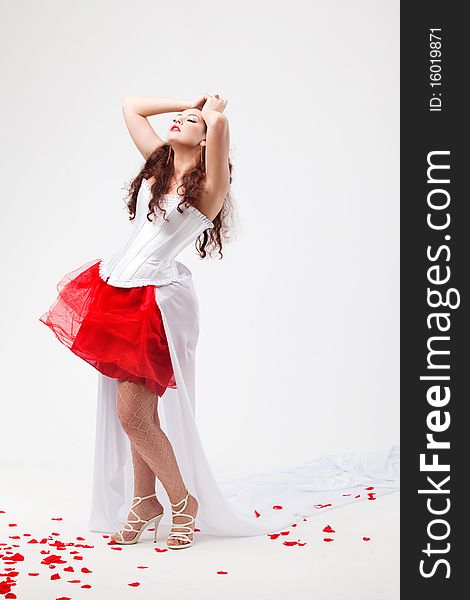 Young beautiful woman with petals of roses, on a white background