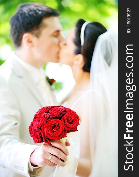 Groom and bride in white dress on background of green trees. Groom and bride in white dress on background of green trees