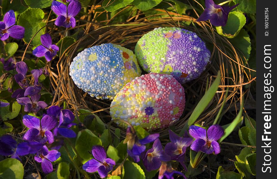 Easter eggs in the nest among violets. Easter eggs in the nest among violets