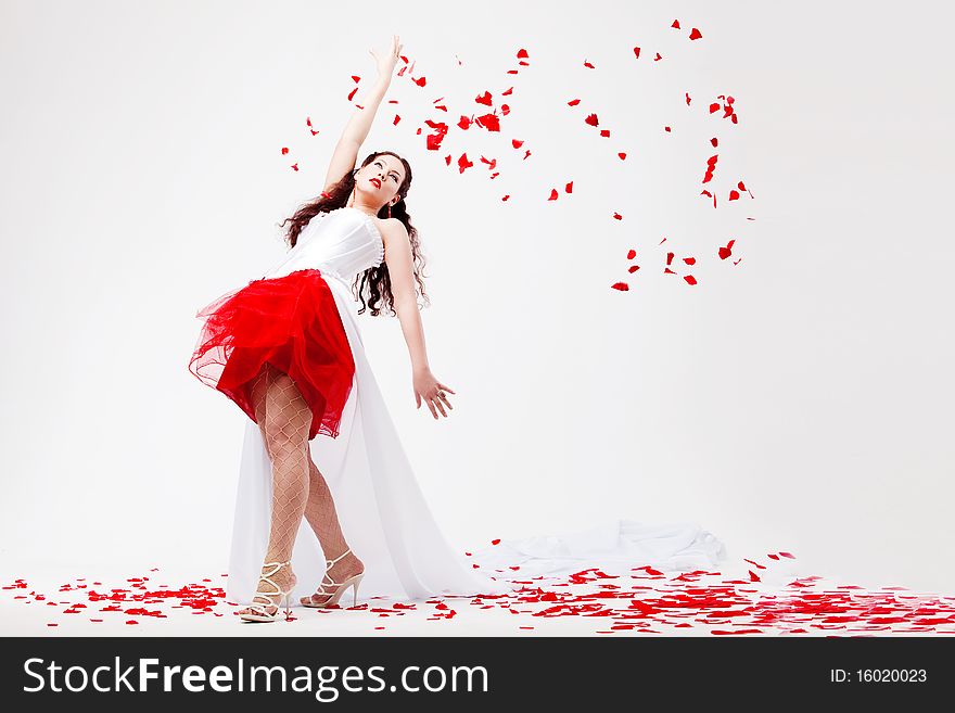 Young beautiful woman with petals of roses, on a white background