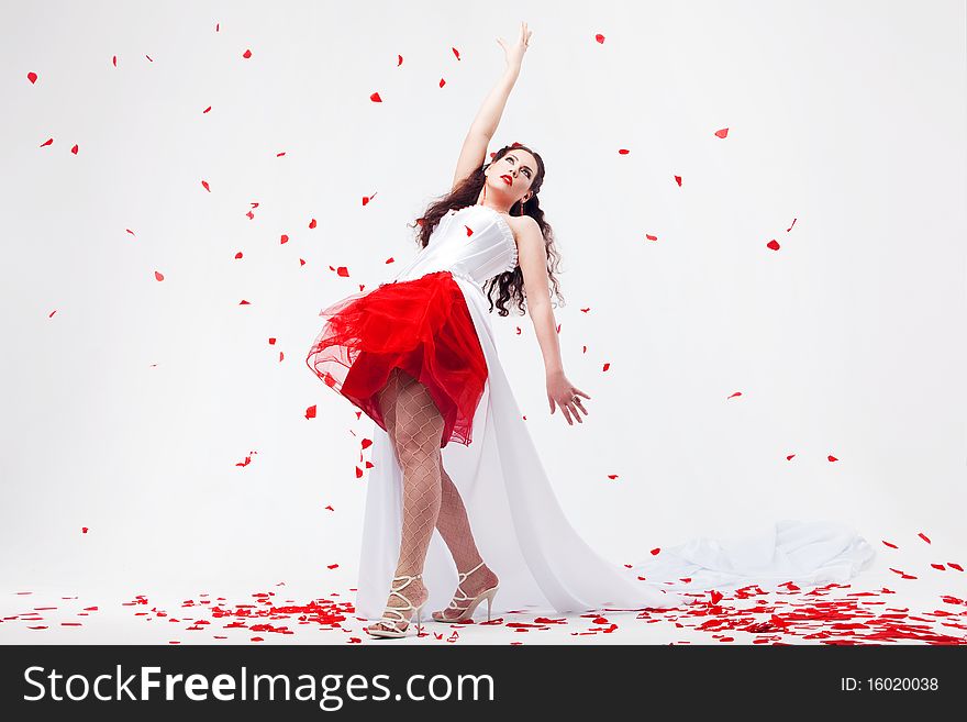 Young beautiful woman with petals of roses, on a white background