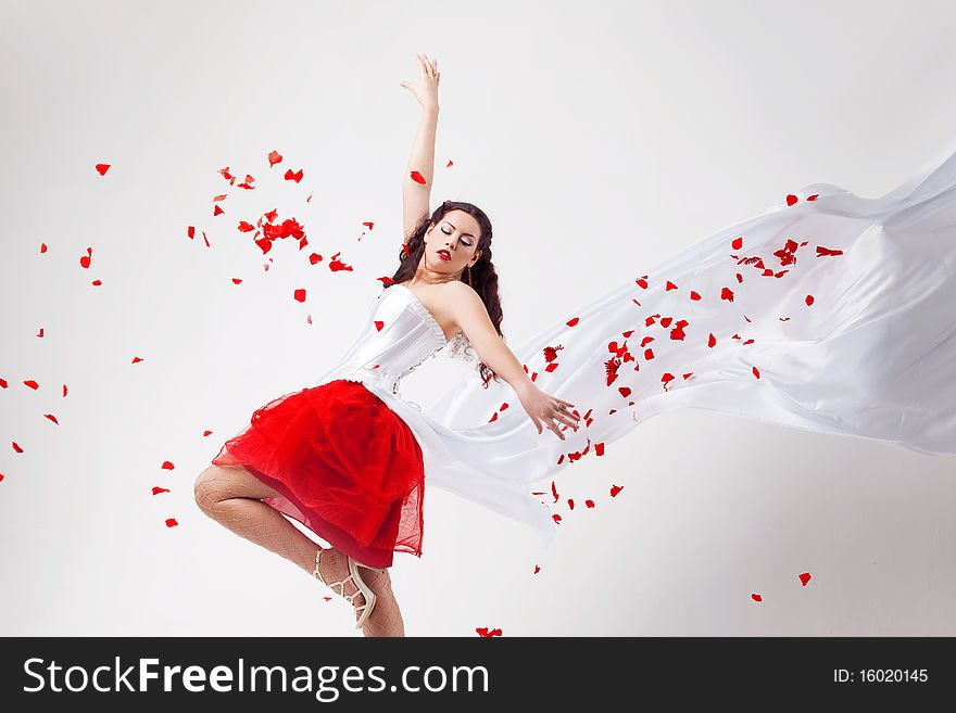 Young beautiful woman with petals of roses, on a white background