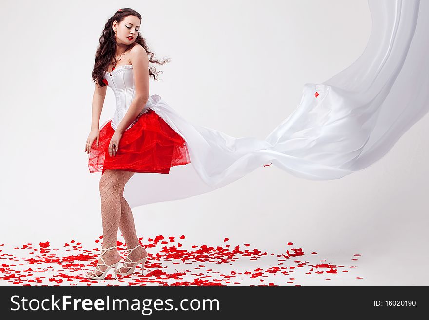 Young beautiful woman with petals of roses, on a white background