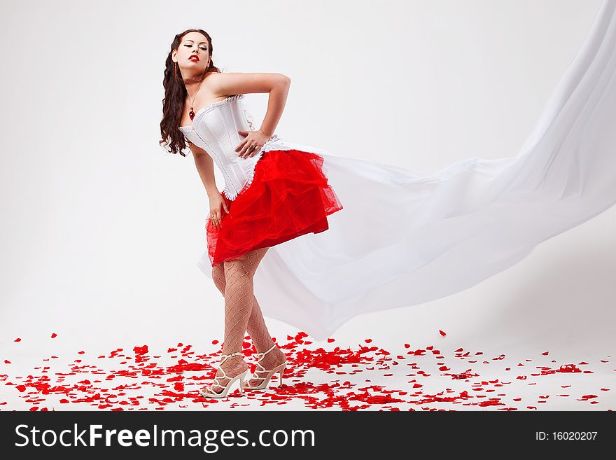 Young beautiful woman with petals of roses
