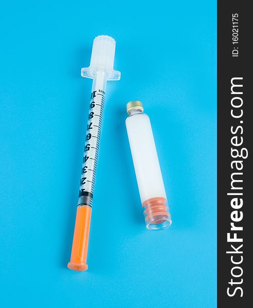 Insulin and syringe on a blue background