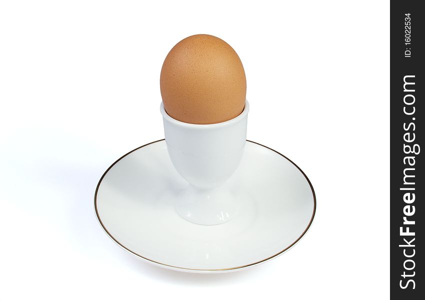 The egg in eggcup is on the white background. The egg in eggcup is on the white background