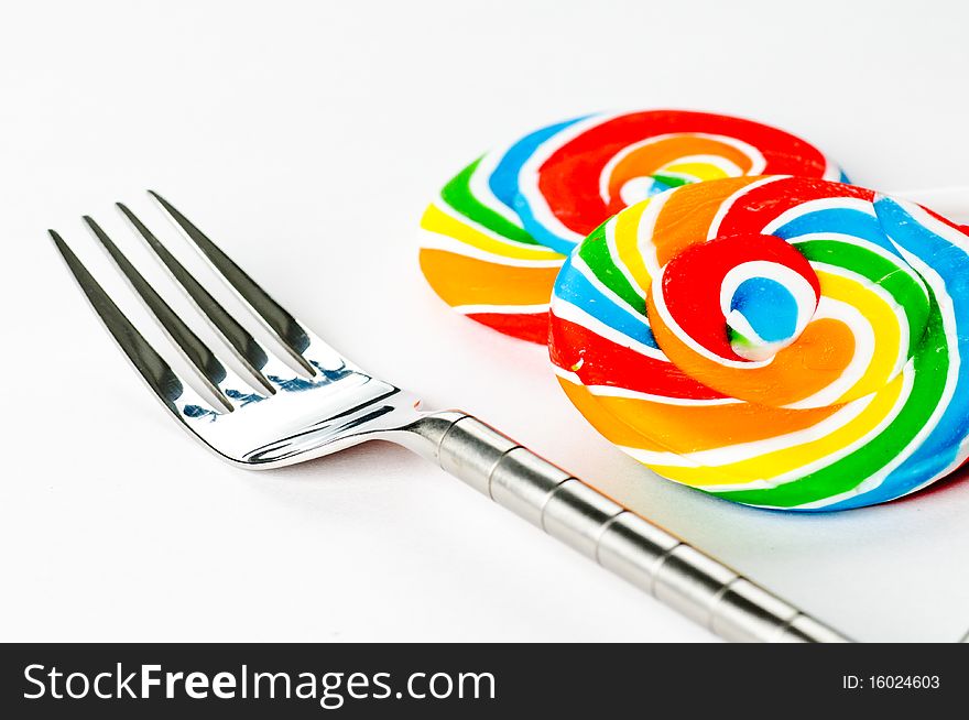 Two lollipops and a fork on a white background. Two lollipops and a fork on a white background