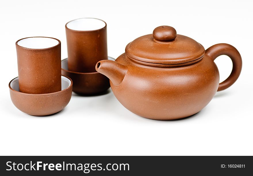 Clay tea pot and cups on a white background