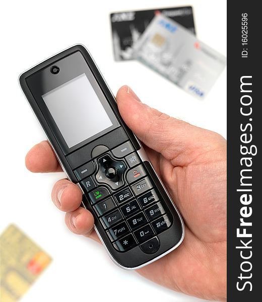 A cordless telephone isolated on a white background with credit cards. A cordless telephone isolated on a white background with credit cards