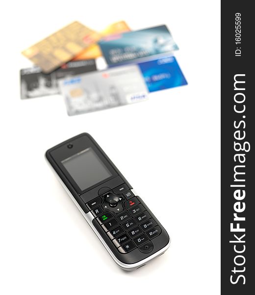 A cordless telephone isolated on a white background with credit cards. A cordless telephone isolated on a white background with credit cards