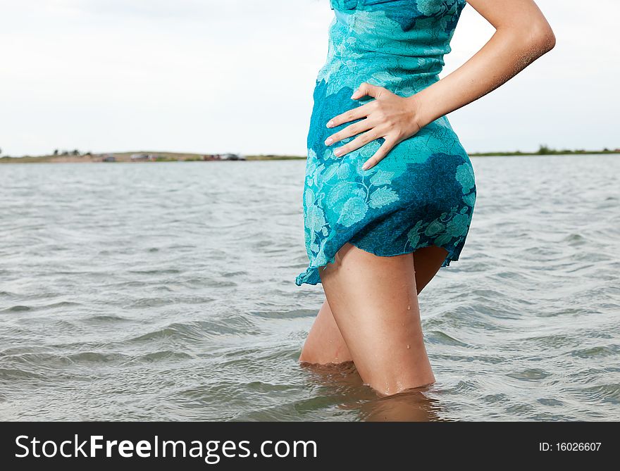 The model in a dark blue bathing suit poses in water. The model in a dark blue bathing suit poses in water