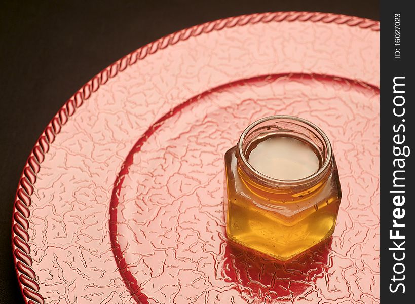 Jars filled with colorful jam on top of a red decorative plate