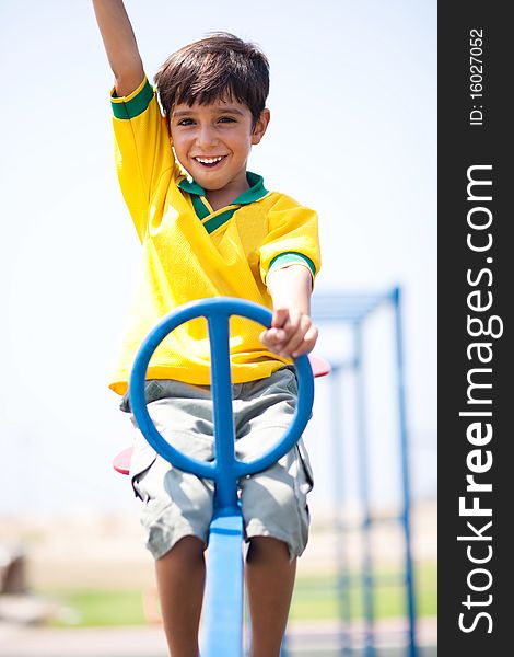 Boy in soccer uniform playing in the park and taking ride on swing. Boy in soccer uniform playing in the park and taking ride on swing