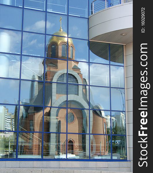 Church reflexion in windows of a modern building