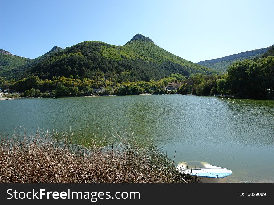 Boat on lake on a mountain and wood background