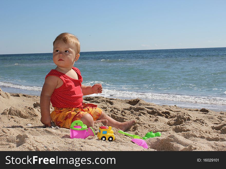 Child is sitting on the sand