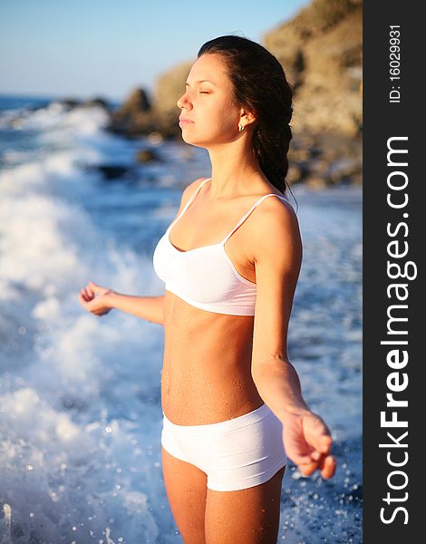 Girl meditates standing in the surf. Girl meditates standing in the surf.