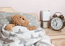 A Teddy Bear Sleeping In The Bed Royalty Free Stock Photo