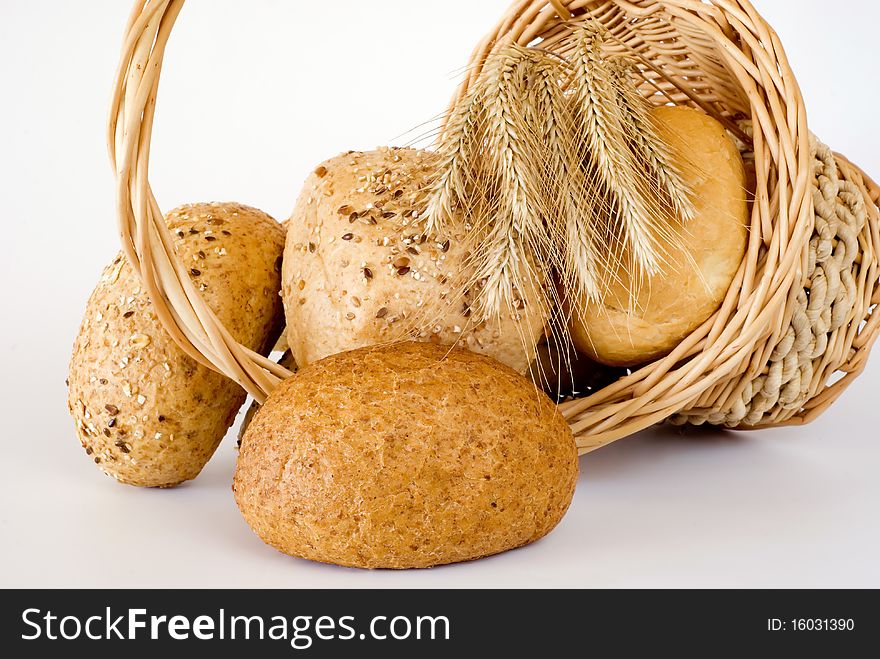 Basket turned over with the fresh bread on the white background. Basket turned over with the fresh bread on the white background