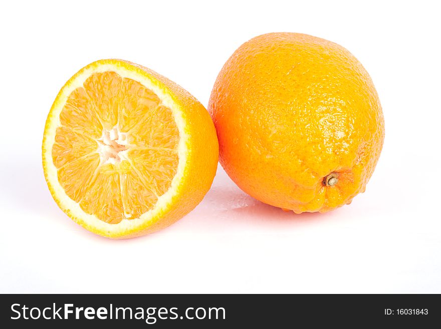 Ripe sliced and whole orange with water drops isolated on white background.